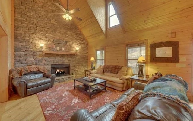 600 Mill Ridge Rd, Hiawassee, GA 30546 - living room with wood walls, wood finished floors, a stone fireplace, ceiling fan, and high vaulted ceiling