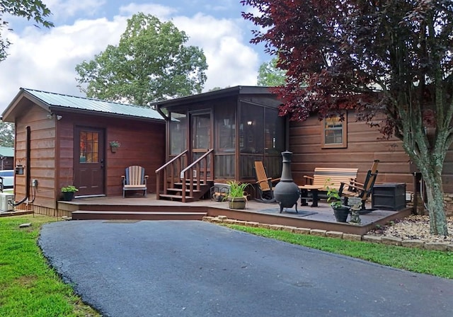 back of house featuring a deck, a patio, and a sunroom