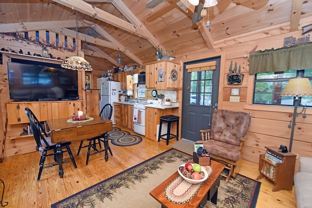 dining room with light hardwood / wood-style flooring, vaulted ceiling with beams, wood ceiling, and wooden walls