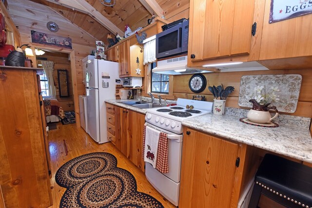 kitchen featuring white appliances, light hardwood / wood-style floors, vaulted ceiling with beams, wood walls, and wood ceiling