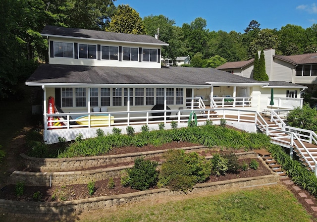 rear view of house featuring stairway and a shingled roof