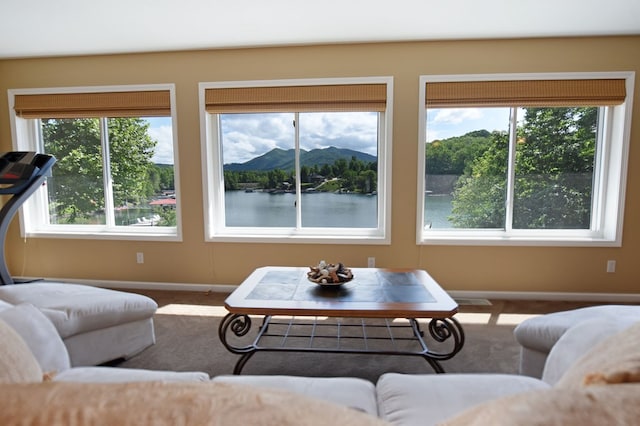 living room featuring baseboards, carpet flooring, and plenty of natural light