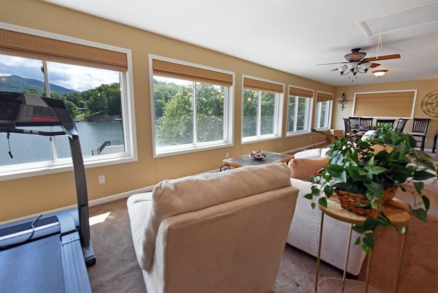 living room featuring baseboards, a mountain view, attic access, ceiling fan, and carpet