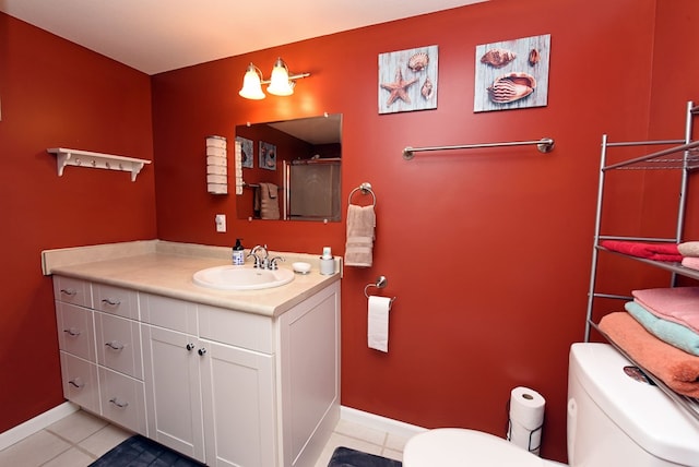 bathroom with tile patterned floors, vanity, baseboards, and toilet