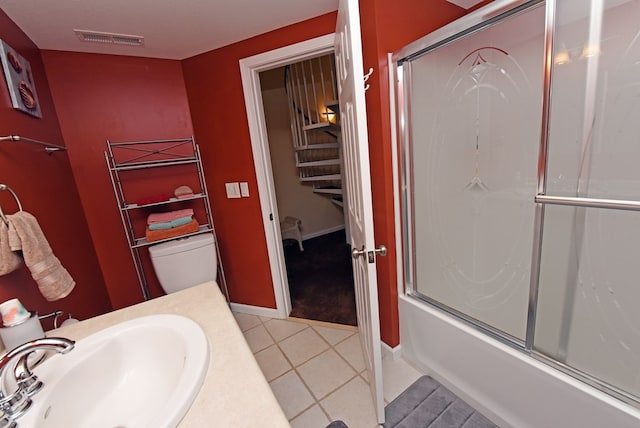 full bath featuring tile patterned flooring, visible vents, enclosed tub / shower combo, a sink, and baseboards