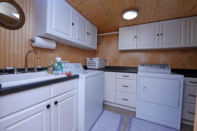 laundry area featuring wood walls, washer and dryer, wooden ceiling, and cabinet space