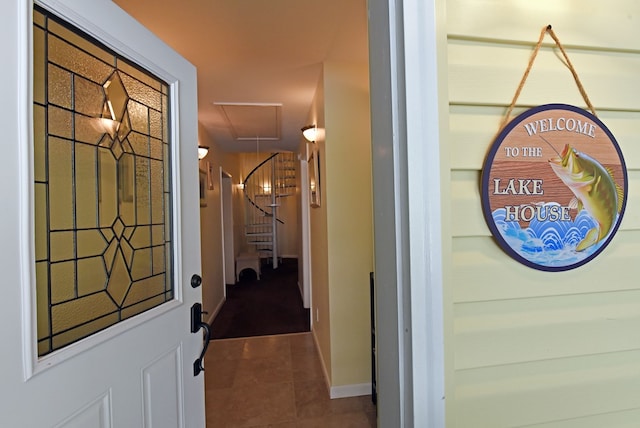 interior space featuring dark tile patterned flooring and baseboards