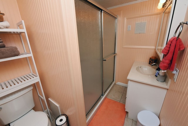bathroom featuring toilet, vanity, a stall shower, and tile patterned flooring