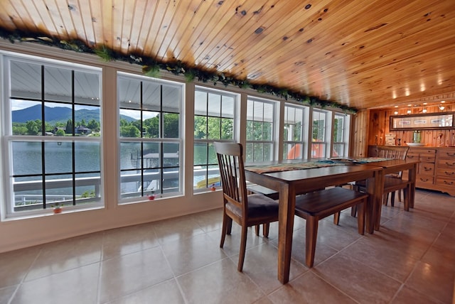 tiled dining area with plenty of natural light, wood ceiling, and a water and mountain view