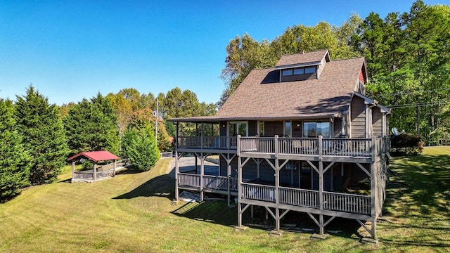 rear view of property featuring a deck and a lawn