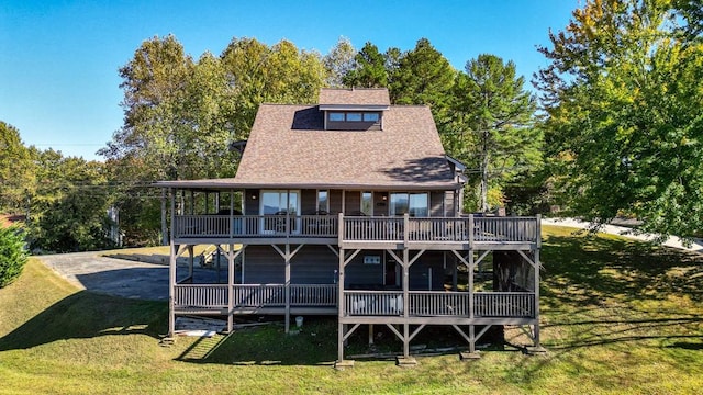 back of property with a yard and a wooden deck