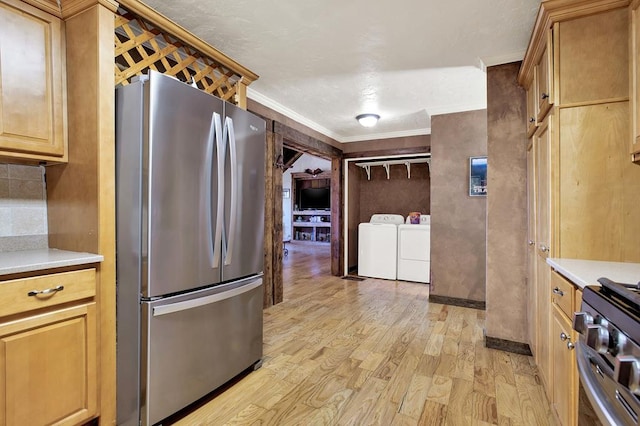 kitchen with light hardwood / wood-style flooring, stainless steel appliances, crown molding, washing machine and clothes dryer, and tasteful backsplash