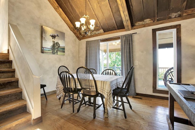 dining space with lofted ceiling with beams, light hardwood / wood-style floors, and plenty of natural light