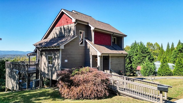 view of front facade featuring a front yard and a deck with mountain view