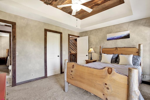 carpeted bedroom featuring ceiling fan and a tray ceiling