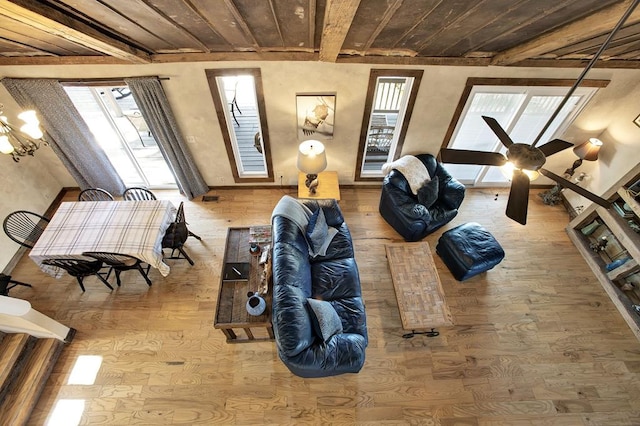 living room featuring beamed ceiling, wood ceiling, wood-type flooring, and ceiling fan with notable chandelier