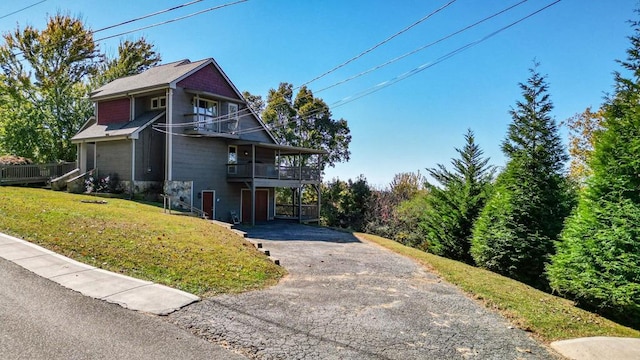 view of side of property with a yard and a balcony