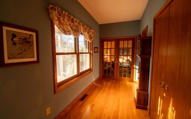 hall featuring french doors and light hardwood / wood-style flooring