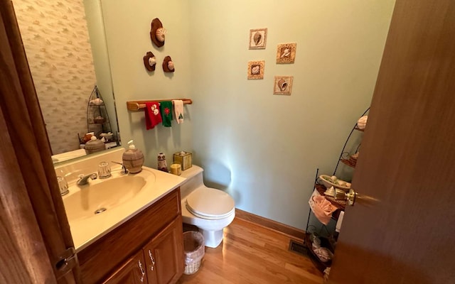 bathroom with vanity, wood-type flooring, and toilet