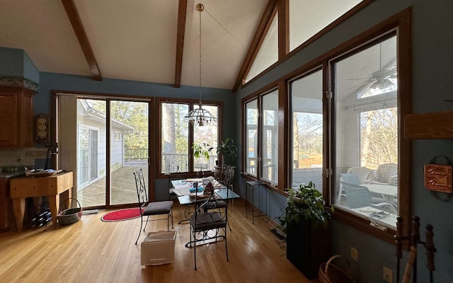 sunroom / solarium featuring ceiling fan and lofted ceiling with beams