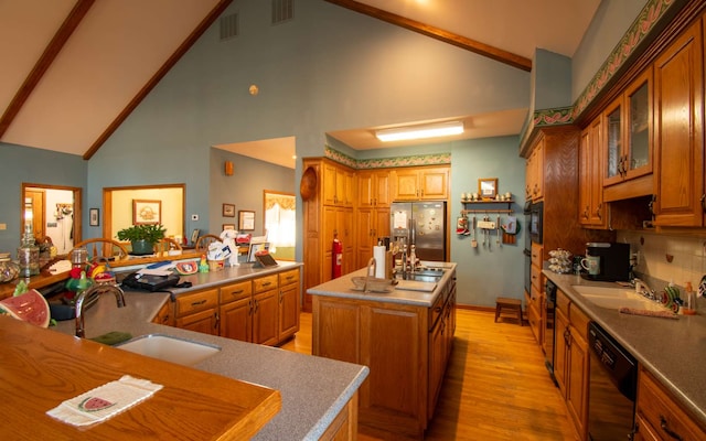 kitchen with stainless steel refrigerator with ice dispenser, sink, a center island, light hardwood / wood-style flooring, and black dishwasher