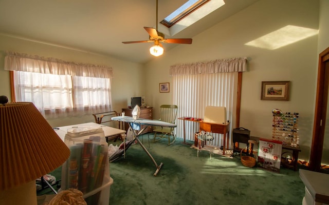 interior space featuring lofted ceiling with skylight, carpet flooring, and ceiling fan