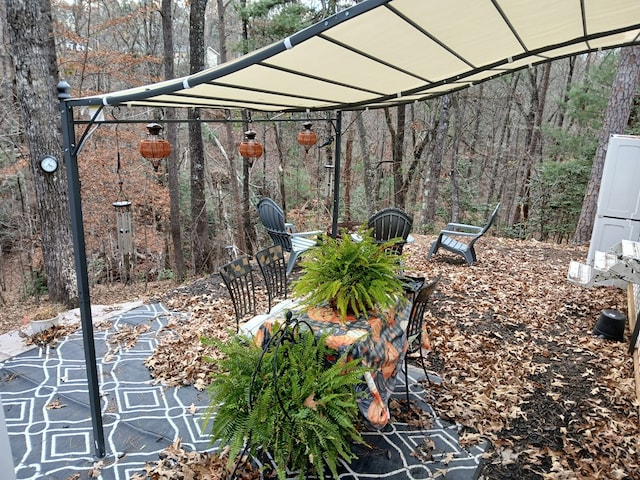 view of yard featuring a carport and a forest view