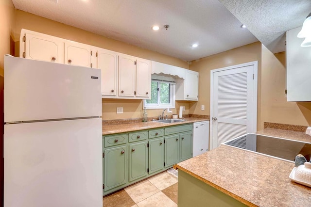 kitchen with a textured ceiling, sink, green cabinetry, white cabinetry, and white appliances