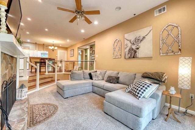 living room with ceiling fan with notable chandelier and light colored carpet