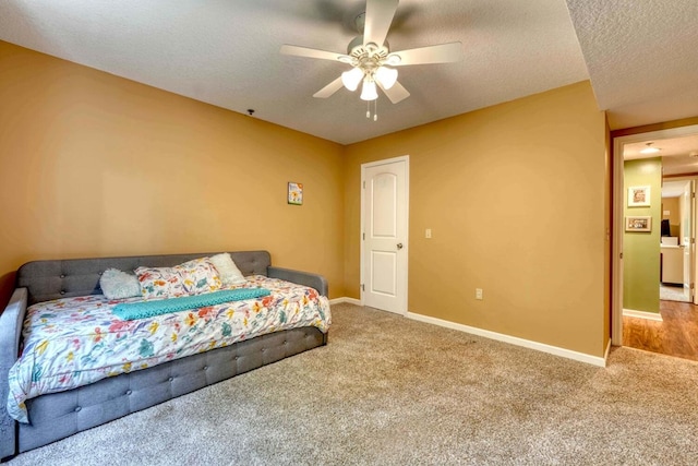 carpeted bedroom with ceiling fan, a textured ceiling, and washer / dryer