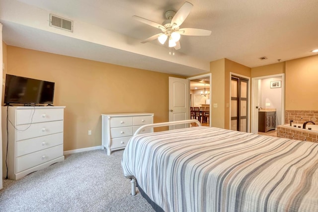 bedroom featuring connected bathroom, a closet, a textured ceiling, ceiling fan, and light carpet