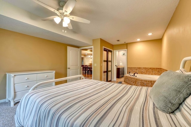 carpeted bedroom with a closet, ceiling fan, ensuite bathroom, and a textured ceiling