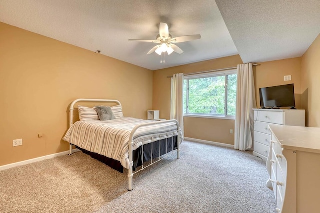 carpeted bedroom with ceiling fan and a textured ceiling