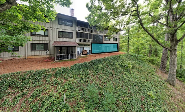 rear view of house featuring a sunroom