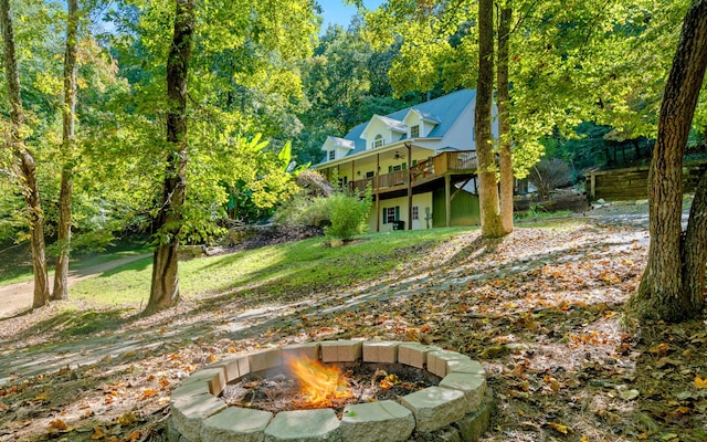 back of property with a wooden deck and an outdoor fire pit