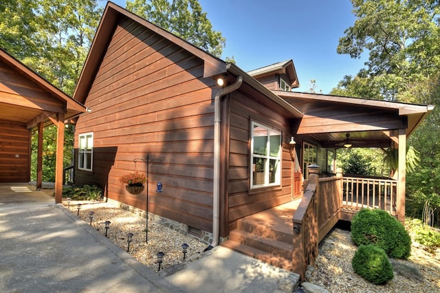 view of side of home featuring ceiling fan and covered porch