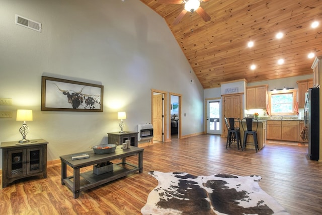 living room featuring wood-type flooring, heating unit, high vaulted ceiling, and wooden ceiling