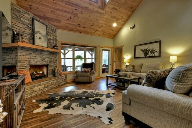 living room featuring a skylight, wood ceiling, hardwood / wood-style flooring, high vaulted ceiling, and a fireplace