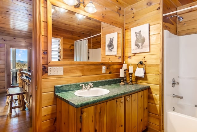 bathroom with shower / bath combination with curtain, vanity, wood walls, and wood ceiling