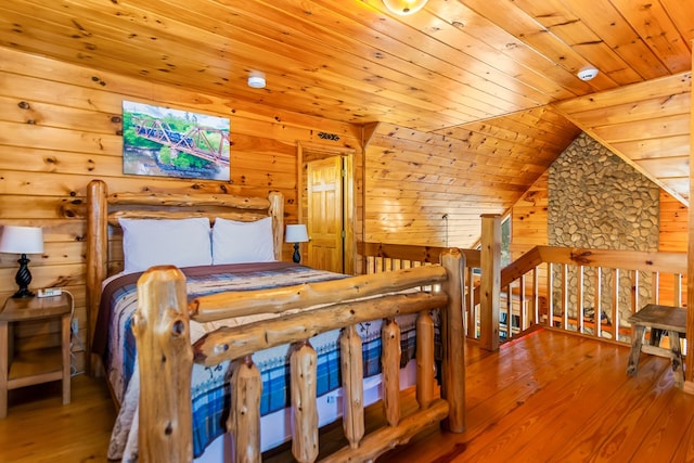 bedroom with wood-type flooring, wood walls, lofted ceiling, and wood ceiling