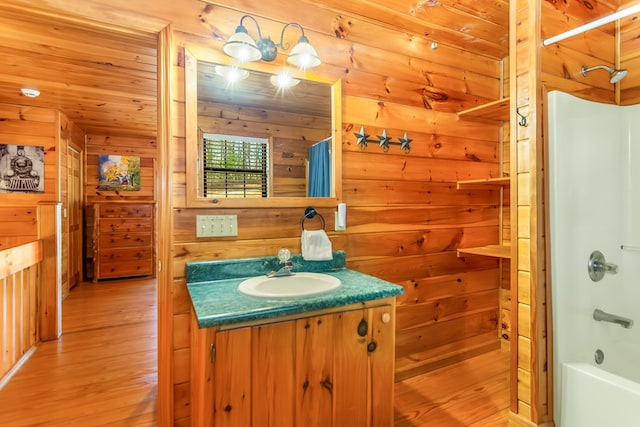 bathroom featuring wooden walls, vanity, shower / bath combination with curtain, and hardwood / wood-style flooring