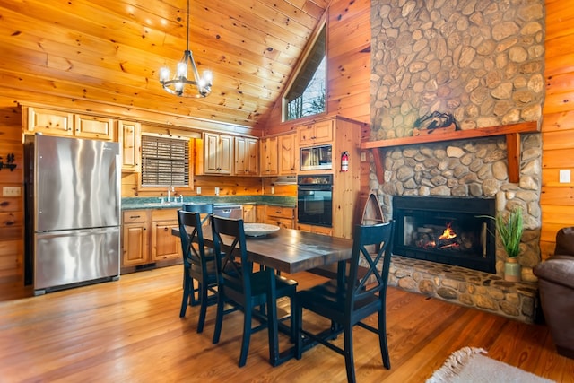 dining space with light hardwood / wood-style floors, a stone fireplace, wood ceiling, and high vaulted ceiling