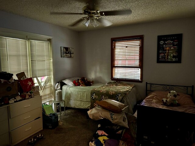 bedroom featuring a textured ceiling, ceiling fan, and carpet