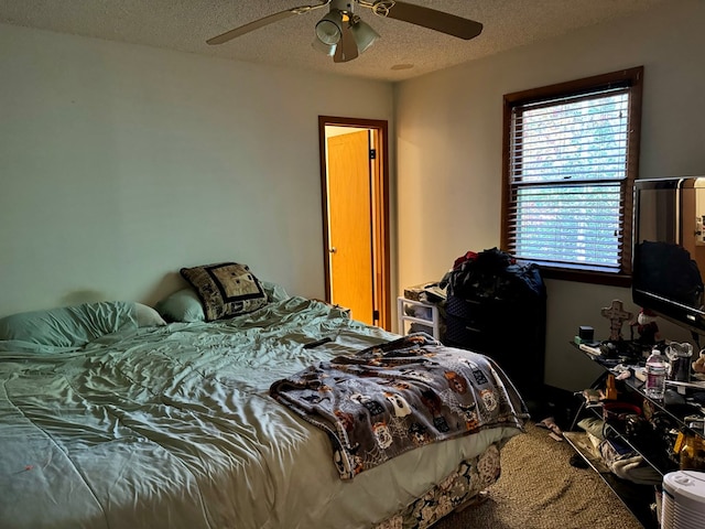 bedroom with a textured ceiling and ceiling fan