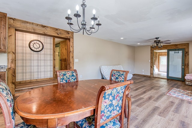 dining area featuring wood finished floors and ceiling fan with notable chandelier