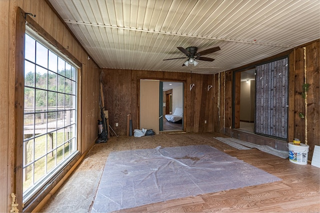 spare room featuring wooden walls and ceiling fan