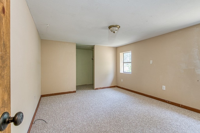 carpeted empty room with baseboards