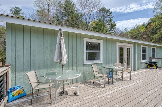 wooden terrace with french doors and outdoor dining space