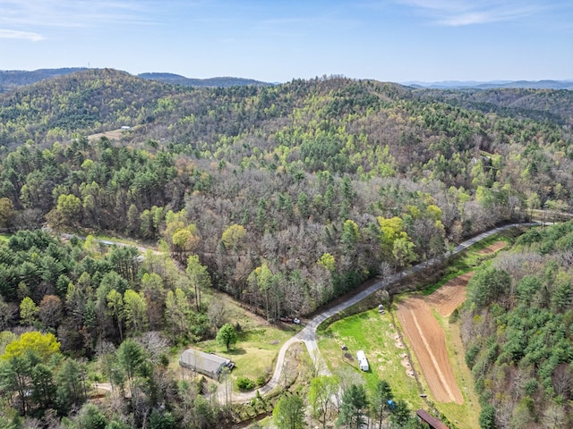 birds eye view of property with a mountain view and a wooded view