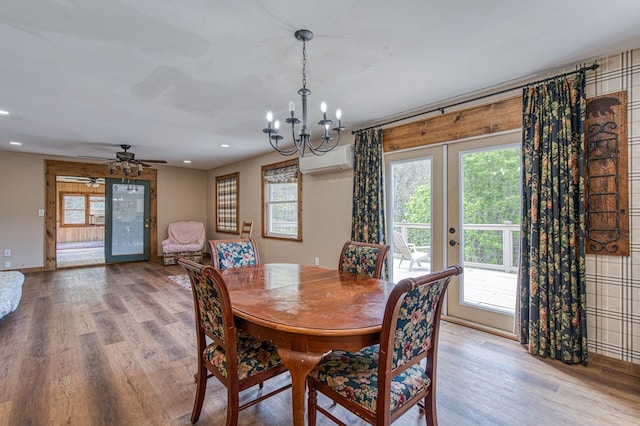dining area with a healthy amount of sunlight, a wall mounted air conditioner, and wood finished floors
